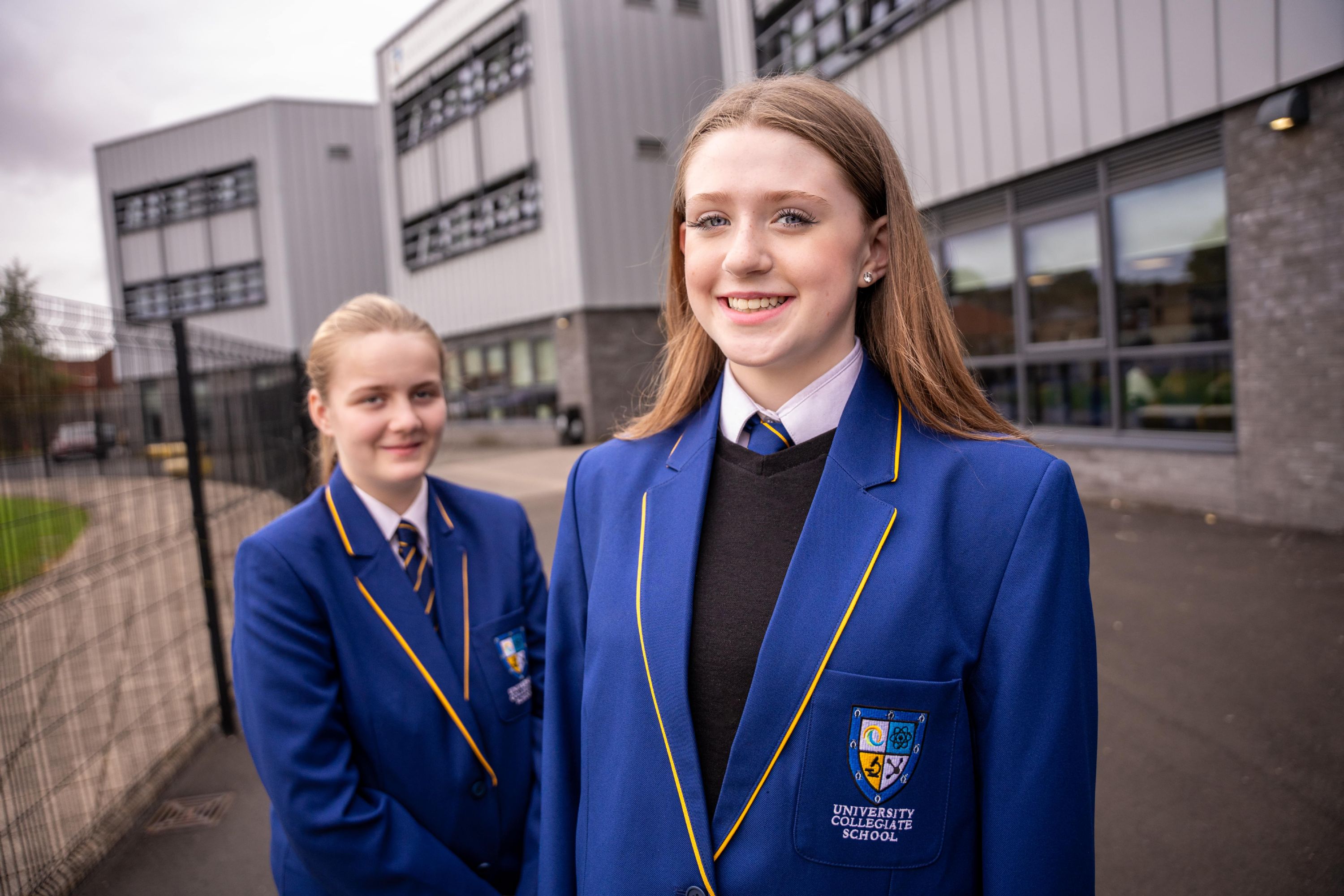 Two female students outside the UCS school building